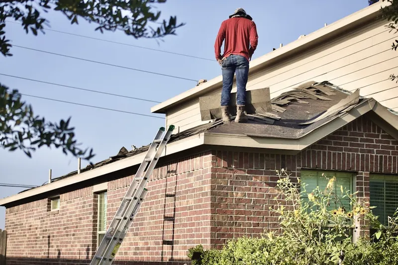 Professional roofer working on a residential roof in Haledon